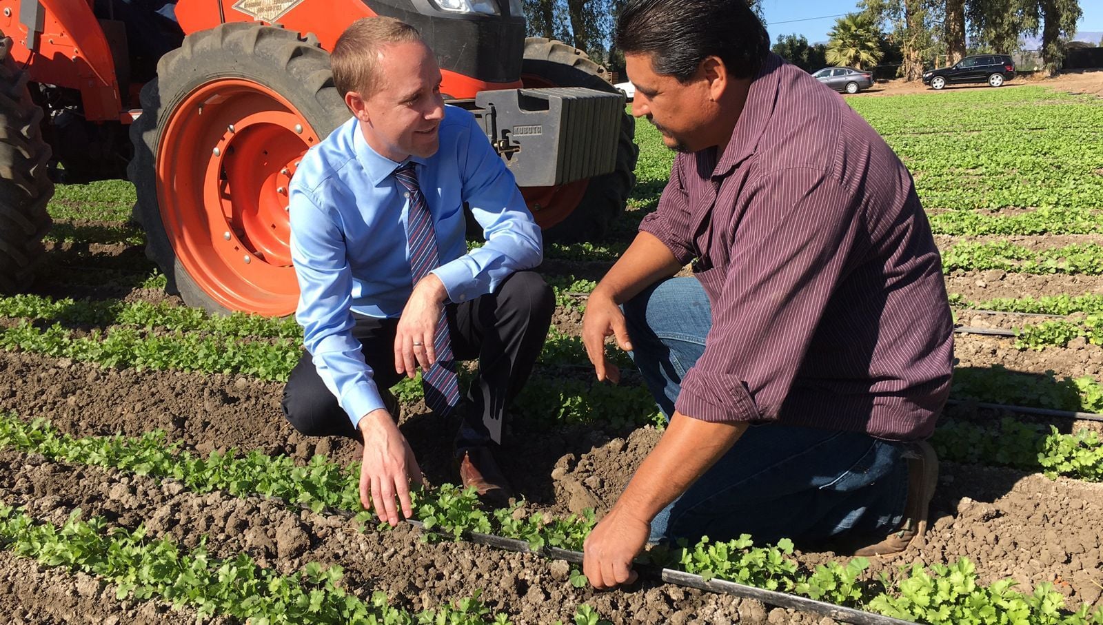 Eric Price conversando con un trabajador en el campo